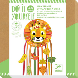 A colorful DIY kit from DJECO for creating a Little Lion Dreamcatcher. The kit showcases a vibrant lion face surrounded by decorative leaves and feathers, ideal for kids aged 4 and up. The packaging highlights a playful design with illustrations and instructions in multiple languages.