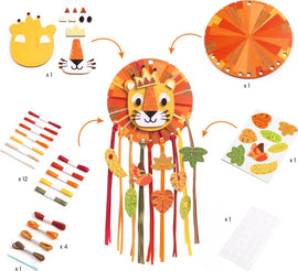 A colorful DIY kit for creating a Little Lion Dreamcatcher by DJECO. The kit includes a lion face, decorative leaves, ribbons in various colors, and stickers. The lion features a crown and vibrant mane with engaging elements like feathers and foliage, promoting creativity and craft skills.