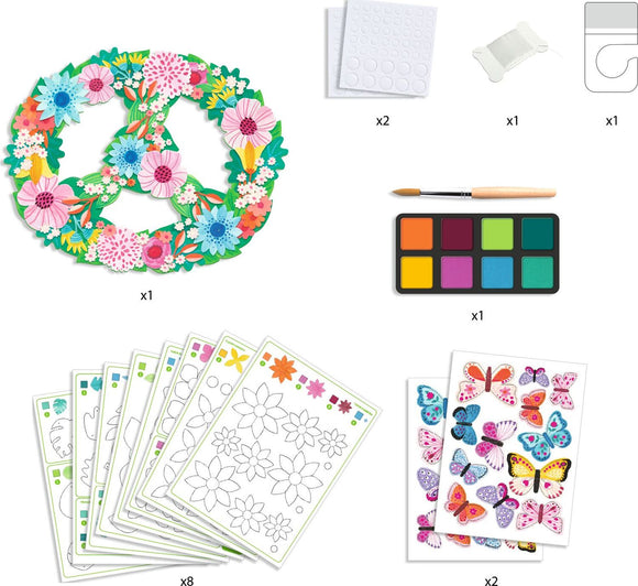 A DIY craft kit featuring a decorative mobile shaped like a peace symbol, adorned with colorful flowers and butterflies. The kit includes watercolor paints, a brush, and patterned sheets for enhancing creative projects.