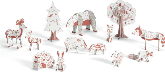 Woods - Color. Assemble. Play. DIY kit by Djeco featuring a whimsical forest scene with various animal figurines including a bear, deer, fox, and more, all designed for engaging imaginative play and creativity.