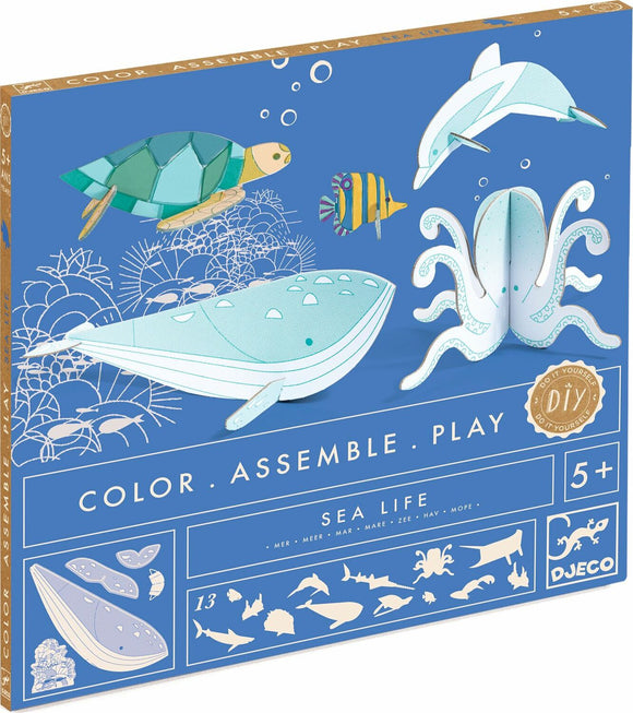 A colorful DIY kit titled "Sea Life - Color. Assemble. Play." by Djeco. The box features illustrations of various sea creatures including a whale, dolphin, turtle, and octopus, designed for children aged 5 and up. Promotes creativity and hands-on play through assembling and coloring marine life figures.