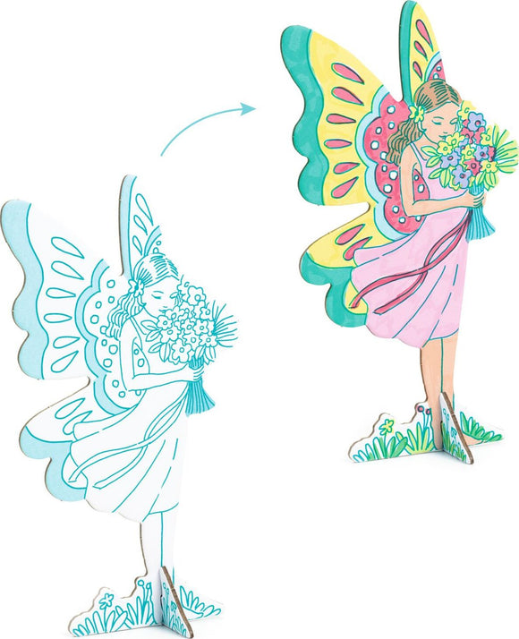 A colorful DIY kit titled 'Fairy World Color. Assemble. Play.' by DJECO. The image displays two fairy figures, one in a simple outline and the other brightly colored, holding a bouquet of flowers with vibrant wings. Perfect for imaginative play, encouraging creativity, and hands-on crafting.