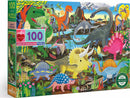 Eeboo's Land of the Dinosaurs jigsaw puzzle featuring 100 colorful pieces showcasing various dinosaurs in a vibrant prehistoric landscape. The puzzle highlights a variety of dinosaur species surrounded by lush vegetation, water, and a bright sky, making it an engaging and educational activity for children 5 years and up.