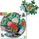 Eeboo's Bouquet & Birds jigsaw puzzle featuring a vibrant circular floral design with various colored flowers and birds, showcasing detailed illustrations and bright colors. A few puzzle pieces are displayed to indicate the puzzle style and design.