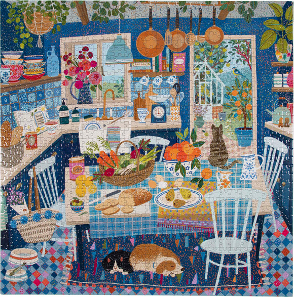 A colorful jigsaw puzzle featuring a cozy and vibrant kitchen scene. The image includes a table abundant with fresh fruits and vegetables, baked goods, and a decorative woven basket. Shelves filled with pottery and culinary tools line the walls, while a window reveals an outdoor garden with greenery. A cat lounges on the patterned floor near the table, enhancing the warm, homey atmosphere.