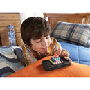 A young boy is focused on solving the Kanoodle mechanical puzzle from Educational Insights. The puzzle features colorful, interlocking pieces that he is arranging on a soft orange surface, with a comfortable bedroom setting in the background.