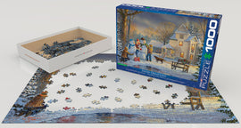 Eurographics Snow Creations jigsaw puzzle featuring a picturesque winter scene with snowmen and a cozy house. The box is open, showing scattered puzzle pieces on a partially completed image of the snowy landscape.