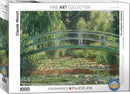 The Japanese Footbridge jigsaw puzzle by Claude Monet, produced by Eurographics. The box features a vibrant image of a serene footbridge over water, surrounded by lush greenery and water lilies, capturing Monet's impressionistic style. The puzzle consists of 1000 pieces and is part of the Fine Art Collection.
