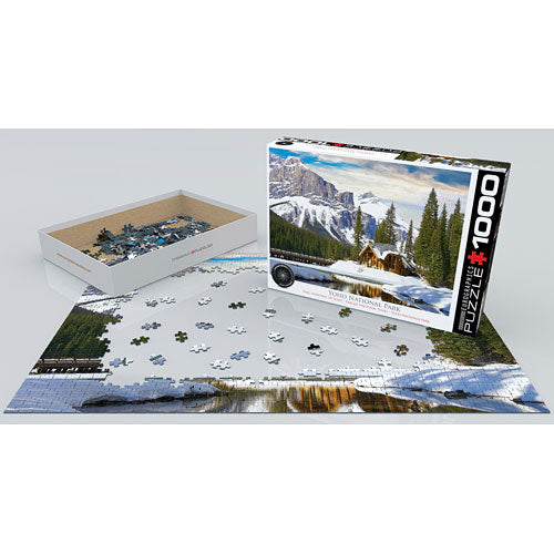 A 1000-piece jigsaw puzzle titled 'Yoho National Park British Columbia' by Eurographics, featuring a scenic landscape with mountains, a lake, and trees. The box is partially opened, revealing colorful puzzle pieces arranged next to the layout of the partially completed puzzle on a flat surface.