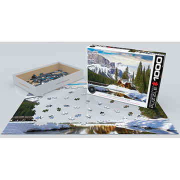 A 1000-piece jigsaw puzzle titled 'Yoho National Park British Columbia' by Eurographics, featuring a scenic landscape with mountains, a lake, and trees. The box is partially opened, revealing colorful puzzle pieces arranged next to the layout of the partially completed puzzle on a flat surface.