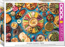 A colorful jigsaw puzzle box featuring an intricate design of a Middle Eastern table filled with various dishes. The spread includes vibrant salads, dips like hummus, olives, and an assortment of pastries, fruits, and traditional Middle Eastern delicacies, all arranged beautifully against a blue background.