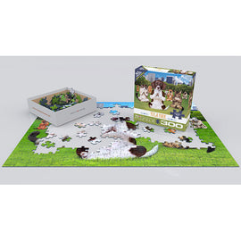 A 300-piece jigsaw puzzle titled 'Yoga Park' by Eurographics, displayed partially assembled on a green grass background. The puzzle features playful dogs in a park setting. The open box with puzzle pieces is placed on the left, showing various colorful jigsaw pieces ready to complete the image.