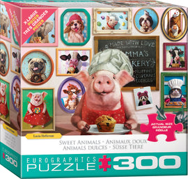 Box design of the Delicious Goodies jigsaw puzzle by Eurographics featuring a cheerful pig in a chef's hat holding a muffin. The background displays framed photos of animals in playful baking scenarios, underlining a fun, whimsical theme.