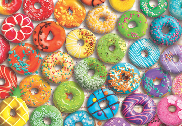 A colorful arrangement of donuts featuring various icing and toppings, including sprinkles, fruit pieces, and chocolate drizzles. Each donut showcases a unique design and vibrant colors, making it a visually appealing jigsaw puzzle that captures the delightful essence of sweets.