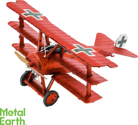 A detailed model of the Fokker Dr.I Triplane, made from metal. The triplane features a vibrant red finish with black and white cross markings. The aircraft is presented in a dynamic angle, showcasing its three wings and propeller. This DIY kit by Fascinations allows enthusiasts to build a miniature replica of this iconic World War I plane.