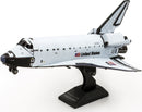 Metal Earth DIY kit of the Space Shuttle Discovery, featuring detailed metal construction pieces that assemble into a realistic model. The model showcases intricate designs that represent the iconic NASA spacecraft, complete with labels and textures, set on a sturdy black stand.