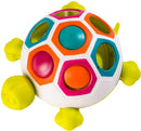 The Pop N Slide Shelly game by Fat Brain Toys features a colorful turtle design with a dome-shaped body adorned with hexagonal openings. Brightly colored buttons in shades of pink, orange, blue, and green are strategically placed on the surface, inviting tactile play. The turtle includes four small feet and a cheerful expression, making it visually appealing for children.