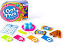 The game 'I Got This!' by Fat Brain Toys, featuring a colorful box and various game components including blue balls, cards, action tags, and measuring tape. It's designed for ages 8 and up, accommodating 2 to 12 players. The game encourages confidence and skill development.