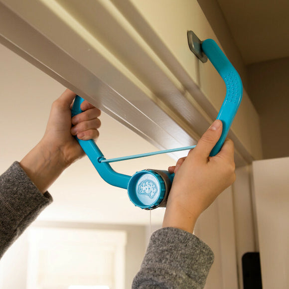 A person setting up the Swingin' Shoes game by Fat Brain. The game features a bright blue frame being held up with a string attached to the ceiling, ready for interactive fun.