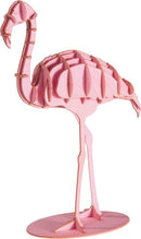 A colorful 3D paper model of a flamingo standing on a round base. The flamingo features an intricate design with layered bright pink paper, showcasing its distinct shape and long legs. Perfect for DIY enthusiasts and crafters looking to create a unique decorative piece.