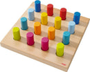 Pegging Game Rainbow Whirls by Haba featuring a wooden board with 16 colorful pegs in vibrant shades of red, orange, yellow, green, blue, and pink. The pegs are arranged in a grid pattern, promoting hands-on learning and fine motor skills. Ideal for children, this game encourages creativity and problem-solving.