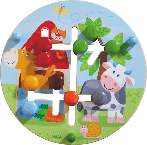 A colorful mechanical puzzle by HABA featuring a bright farm scene with a horse, cow, and a friendly cat. The puzzle includes various colored pegs on a circular board, designed to enhance motor skills in children. Perfect for learning through play.