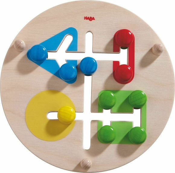 A colorful mechanical motor skills game by HABA featuring a circular wooden base with various shaped cut-outs and vibrant wooden pegs in red, blue, yellow, and green. Kids can manipulate the pegs through the shapes, enhancing their fine motor skills and coordination.