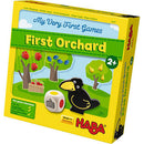 My First Orchard game by HABA USA, featuring colorful illustrations on the box. The box displays trees with apples, a basket, a playful crow figure, and a colorful dice. This engaging game is designed for children aged 2 and up, emphasizing fun learning about colors and teamwork.