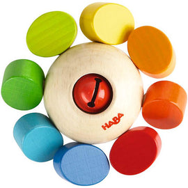 Haba Clutching Toy Whirlygig featuring a central round wooden ball with a red button and surrounded by colorful circular discs in green, yellow, orange, blue, and red. The toy encourages tactile exploration and motor skills development for young children.