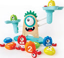The Monster Math Scale by HaPe International features a playful monster design with colorful number weights. It includes red, blue, green, yellow, and orange counting shapes that are used for interactive weighing activities. The scale helps children engage in educational play by promoting basic math skills and number recognition.