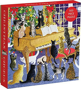 The Christmas Chorus jigsaw puzzle by Galison features a whimsical illustration of cats gathered around a grand piano decorated for the holidays, complete with a Christmas tree and festive decorations. This colorful 500-piece puzzle is perfect for holiday fun with family and friends.