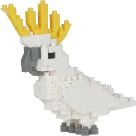 A detailed view of a Nanoblock diorama featuring a sulfur-crest cockatoo, showcasing vibrant yellow feathers and intricate block construction. The bird's body is primarily white with grey accents on the beak and feet, highlighting the creative design.