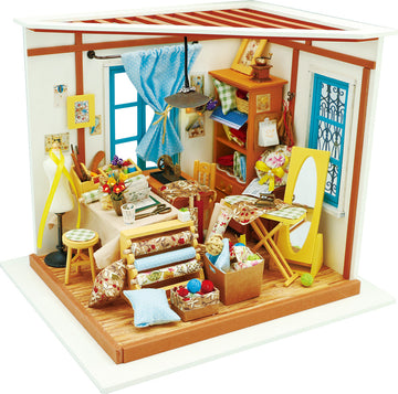 A detailed interior diorama of Lisa's Tailor DIY Model Kit by Robotime, showcasing a vibrant sewing studio with colorful fabrics, a sewing machine, a mannequin, and various crafting supplies arranged around a cozy workspace.