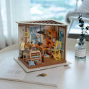 A detailed DIY model kit of Lisa's Tailor, showcasing a miniature tailor workshop with colorful furniture, a sewing machine, and decorative items. The scene is cozy, with a window, bookshelves, and various crafting supplies, displayed in an open box design on a light surface.