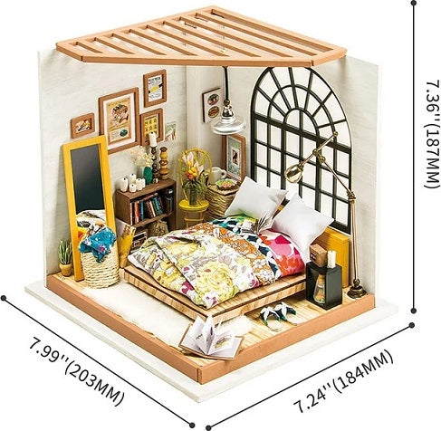 A detailed model kit of a dreamy bedroom, featuring a bed with colorful bedding, a decorative mirror, a bookshelf filled with books and accessories, a cozy corner chair, and a large window that floods the space with natural light. The room showcases a warm color palette with floral accents and artistic decor elements, making it an inviting and creative DIY project.