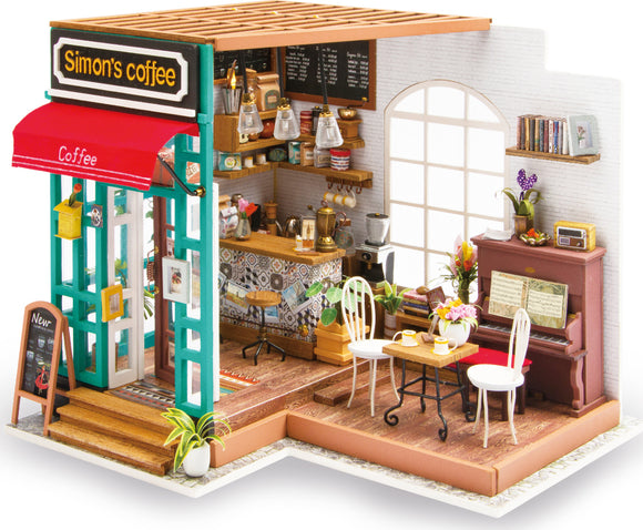 Simon's Coffee Model Kit by Robotime featuring a detailed miniature coffee shop. The model includes a vibrant storefront with a red awning, a decorative coffee menu, a barista counter with coffee brewing equipment, and cozy interior settings with chairs, a small table, a piano, and decorative plants.