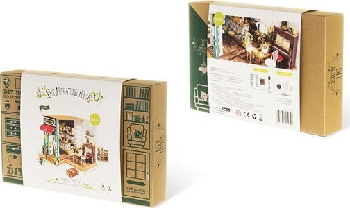 Simon's Coffee Model Kit by Robotime showing the packaging with a colorful illustration of a coffee shop interior and various decorative elements. The box includes DIY project instructions and images of the detailed components inside, ideal for model enthusiasts.