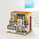 A detailed DIY miniature model of Nancy's Bake Shop from Robotime, featuring intricate interior and exterior designs, including display shelves, a bakery counter, decorative signage, and a cozy ambiance, ideal for craft enthusiasts.