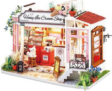 A detailed model kit of a Honey Ice Cream Shop, featuring colorful ice cream cones on the roof, charming outdoor plants, and a cozy interior with a counter, decorations, and a cute bear figure. The shop showcases intricate design elements, inviting decor, and a bright, cheerful aesthetic, perfect for DIY enthusiasts.