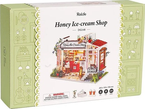 A beautifully designed Honey Ice Cream Shop Model Kit by Robotime. The packaging showcases a charming miniature shop with intricate details, perfect for DIY enthusiasts. The box features playful illustrations and essential details about the kit. Ideal for creating a delightful craft experience.