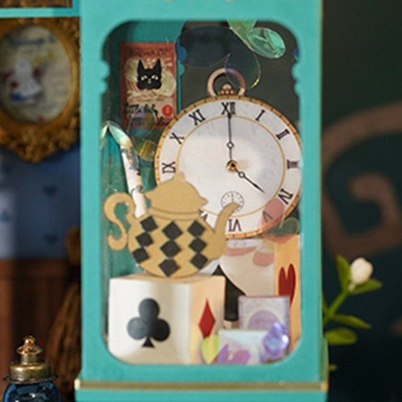 A detailed close-up of Alice's Tea Store DIY kit by Robotime. The scene features a colorful teapot, a clock, and whimsical decor elements, including playing card motifs and decorative boxes. This intricate model captures the enchanting essence of Alice in Wonderland with its vibrant colors and charming accessories.