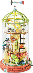 The Domed Loft Model Kit by Robotime features a whimsical three-tiered structure enclosed in a glass dome. Each tier showcases intricate details such as a green rooftop, tiny furniture, colorful flowers, and a whimsical weather vane, creating a charming and magical atmosphere for DIY enthusiasts.