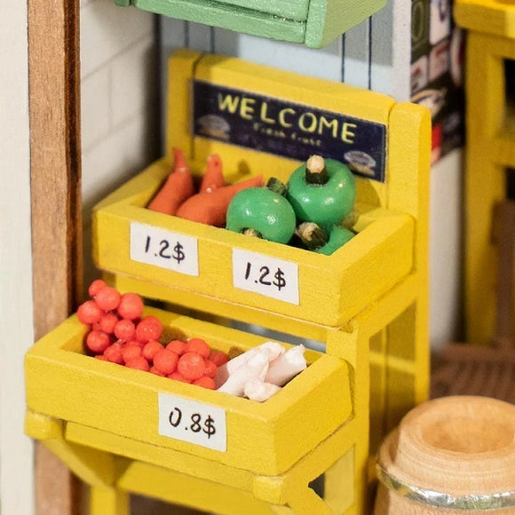 A detailed model kit of a morning fruit store, featuring miniature colorful fruits and vegetables displayed in wooden crates with price tags. The store has a welcoming sign and a rustic aesthetic, perfect for DIY enthusiasts.
