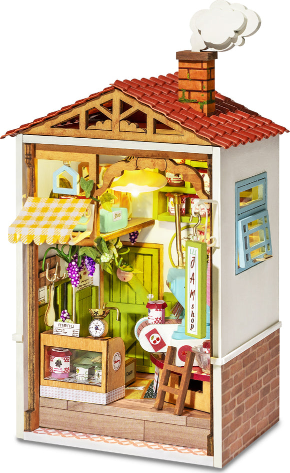 The Sweet Jam Shop Model Kit features a charming miniature shop front with a red-tiled roof, colorful door, and detailed interior. It has a welcoming sign, charming decor with jam jars, and a small outdoor area. The intricately designed space includes working lights, a small table and chairs, and various decorative elements like grapes and a menu. Ideal for DIY enthusiasts and creative hobbyists.