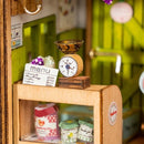 Close-up of the Sweet Jam Shop Model Kit, showcasing a miniature scale, colorful jars of jam, and a detailed menu on the wall, all in a charming shop interior.
