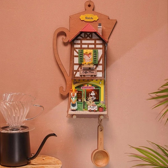 A decorative wooden DIY kit titled 'Lazy Coffee House' by Robotime, designed to resemble a charming coffee shop. The kit features intricate details including window shutters, cute figurines, and a vibrant coffee shop facade, with a playful teapot shape. Ideal for crafting enthusiasts and home decor lovers.