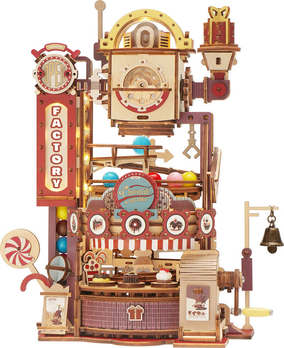 The Chocolate Factory Marble Run Model Kit by Robotime is a detailed DIY kit featuring a colorful, whimsical design. The model showcases a chocolate factory with vibrant multi-colored balls traveling through intricate pathways, candy decorations, and mechanized elements. It's perfect for crafting enthusiasts, combining creativity and engineering to create a fun, interactive display piece.