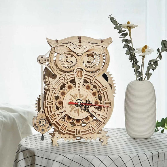 The Owl Clock 3D Build Kit by Robotime is an intricate DIY kit featuring a beautifully crafted wooden owl design with a functional clock face. This mechanical clock showcases detailed gears and a pendulum, making it both a decorative piece and a fun project to assemble. The natural wood finish enhances its aesthetic appeal, perfect for home decor.