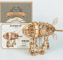 A detailed Airship 3D Puzzle Kit from Robotime, showcasing a beautifully crafted wooden airship model. The assembled airship features intricate designs and is displayed alongside its packaging, which includes intricate illustrations and product information. The puzzle kit contains 176 pieces and is categorized as a DIY mechanical puzzle, aimed at ages 14 and up.