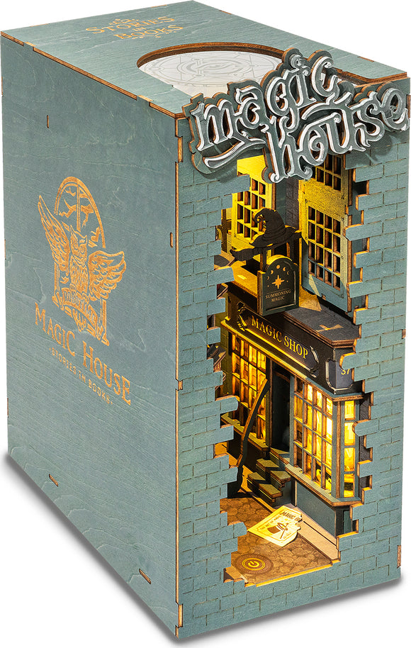 The Magic House DIY Book Nook by Robotime is an intricately designed miniature model featuring a cozy magic shop setting. The exterior is a charming teal color with the words 'Magic House' embossed on the front. Inside, warm golden lights illuminate the details, showcasing shelves filled with magical items and a quaint desk. The cut-out design allows for a peek into this enchanting world, perfect for book lovers and DIY enthusiasts.
